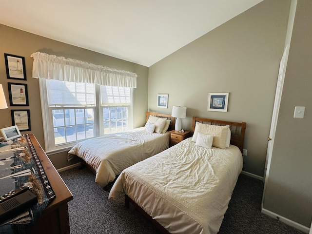 bedroom featuring dark colored carpet, vaulted ceiling, and baseboards