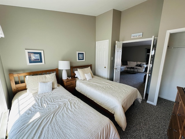 bedroom featuring a towering ceiling, baseboards, dark colored carpet, and a closet