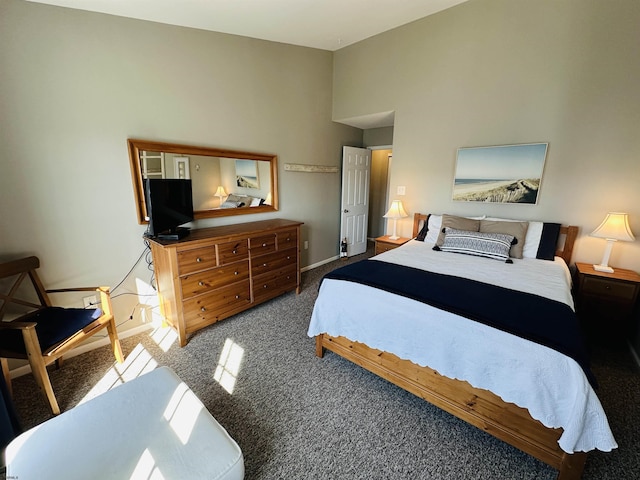 carpeted bedroom with a high ceiling and baseboards