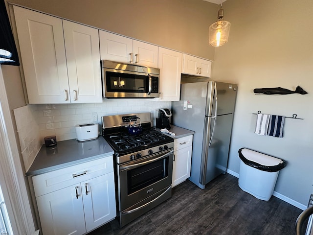 kitchen with appliances with stainless steel finishes, white cabinets, dark wood finished floors, and tasteful backsplash