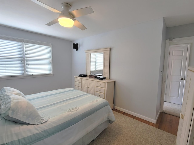 bedroom featuring ceiling fan, baseboards, and wood finished floors