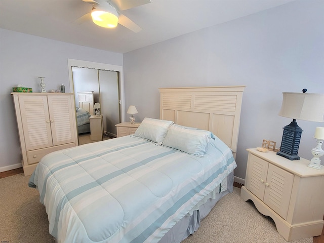 bedroom featuring ceiling fan, a closet, light carpet, and baseboards