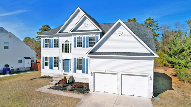 traditional-style home featuring a garage, a front yard, driveway, and a shingled roof