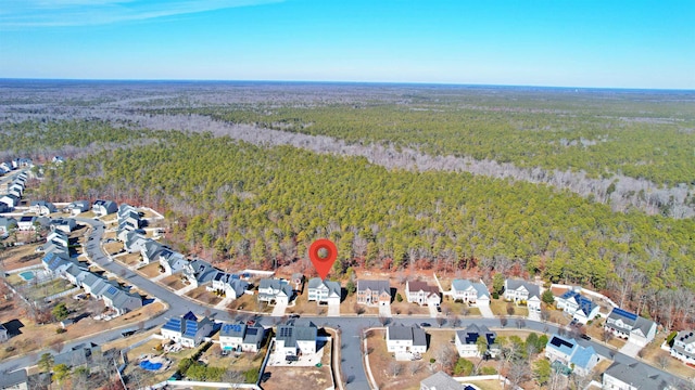 birds eye view of property featuring a residential view and a wooded view