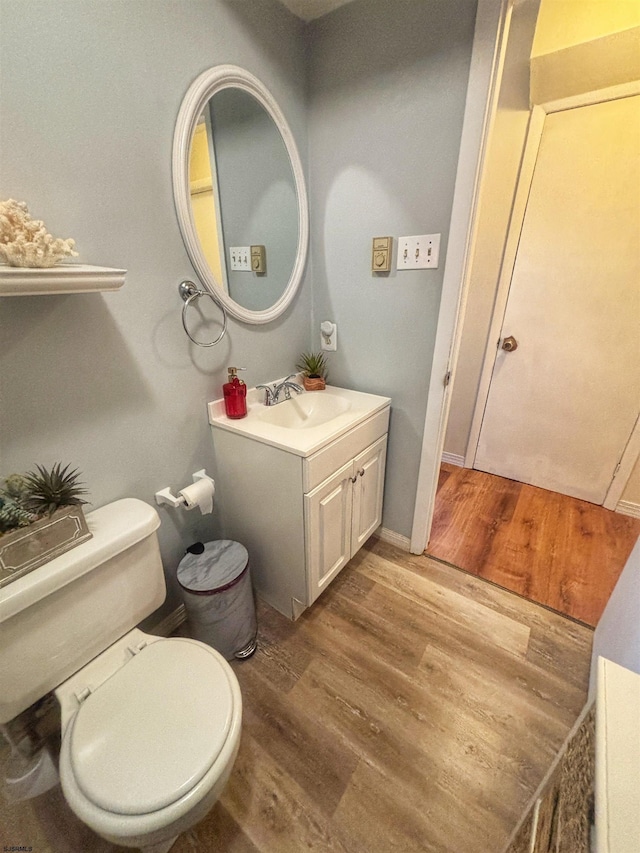 bathroom featuring vanity, toilet, and wood finished floors