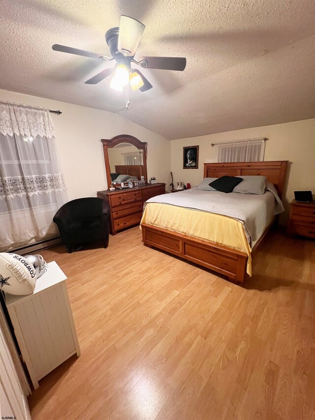 bedroom with a textured ceiling, ceiling fan, vaulted ceiling, and wood finished floors