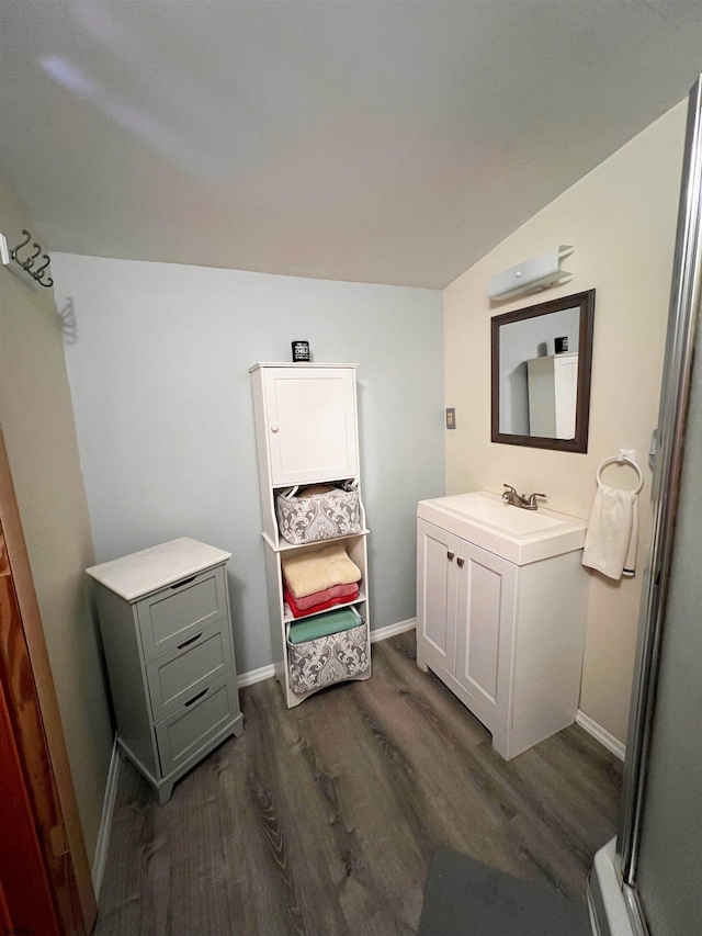 bathroom featuring vanity, baseboards, and wood finished floors