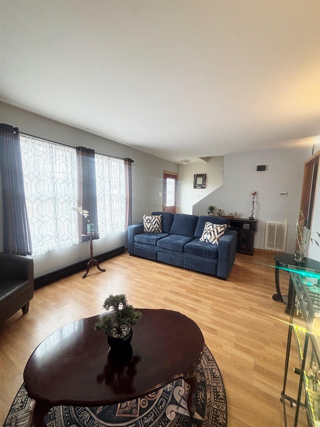 living area with visible vents and wood finished floors