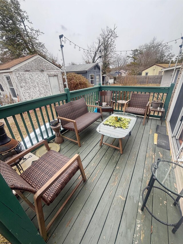 deck with an outbuilding, a storage shed, fence, and a residential view