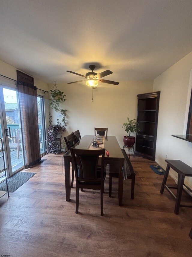 dining space with ceiling fan and wood finished floors