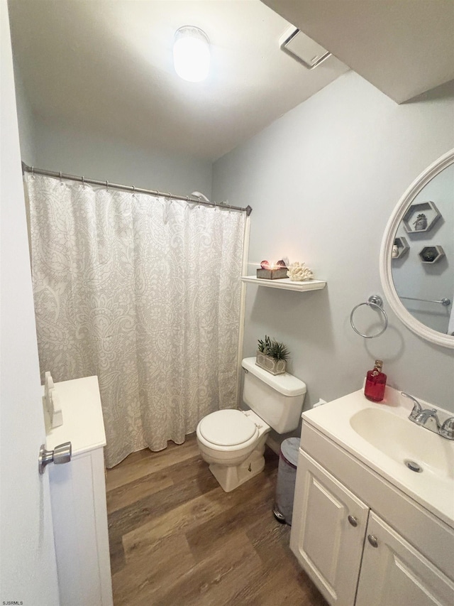 bathroom with toilet, wood finished floors, and vanity