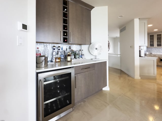 bar with recessed lighting, beverage cooler, visible vents, decorative backsplash, and a bar