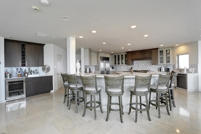 kitchen with light countertops, wine cooler, built in fridge, and glass insert cabinets