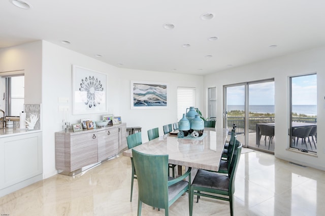 dining space with recessed lighting, a water view, and visible vents