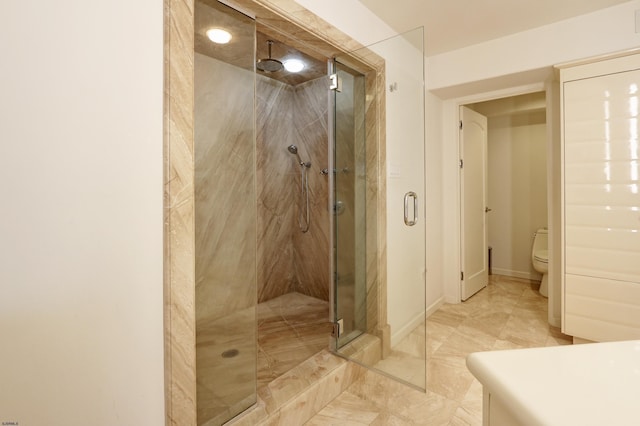 bathroom with baseboards, a shower stall, and toilet