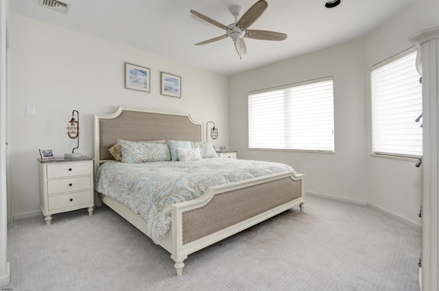 bedroom featuring light colored carpet, visible vents, and multiple windows