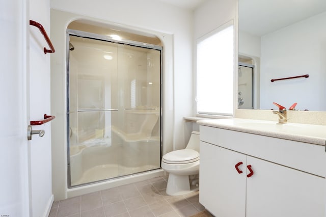 full bathroom featuring a stall shower, vanity, toilet, and tile patterned floors