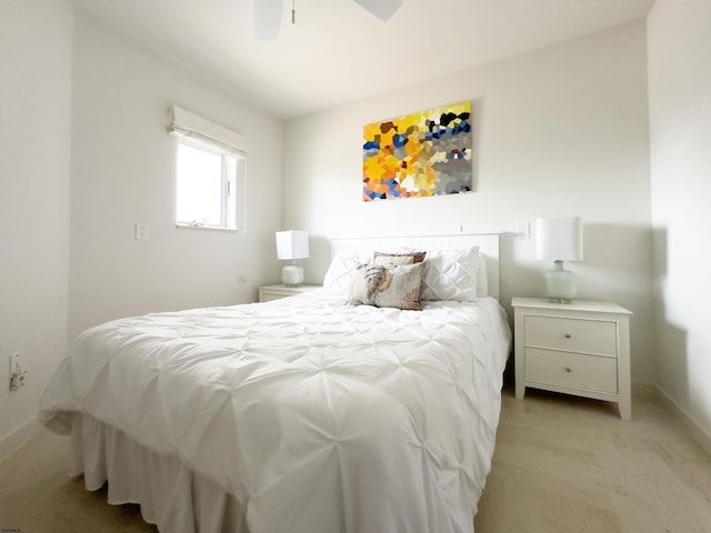 bedroom with ceiling fan, baseboards, and light colored carpet