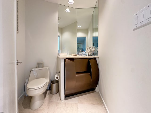 bathroom featuring toilet, baseboards, and recessed lighting