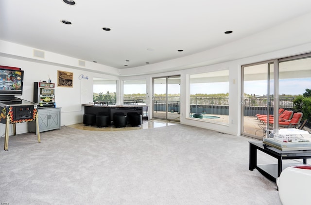 living area featuring recessed lighting, light colored carpet, and visible vents