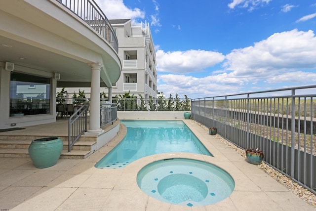 view of pool with a fenced in pool, fence, a patio, and an in ground hot tub