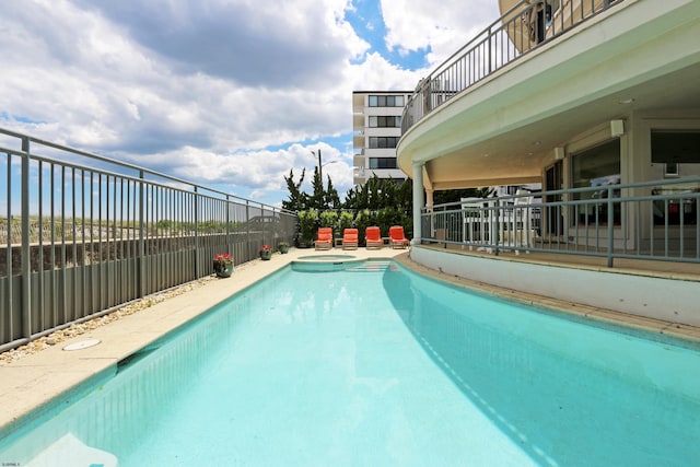 view of pool with a pool with connected hot tub and fence