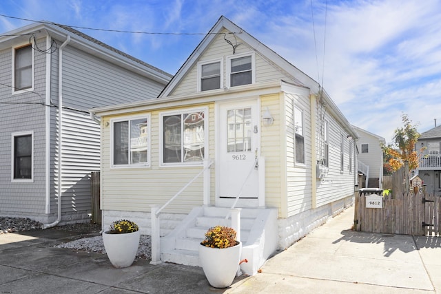 view of front of property with entry steps, fence, and concrete driveway