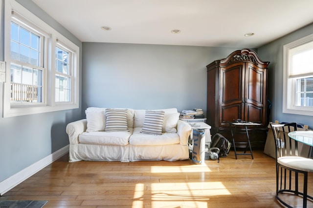 living area with baseboards, recessed lighting, and light wood-style floors