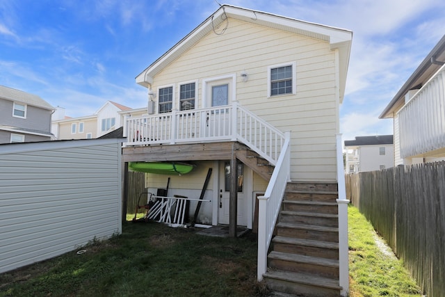 back of property featuring fence private yard, a wooden deck, and stairs