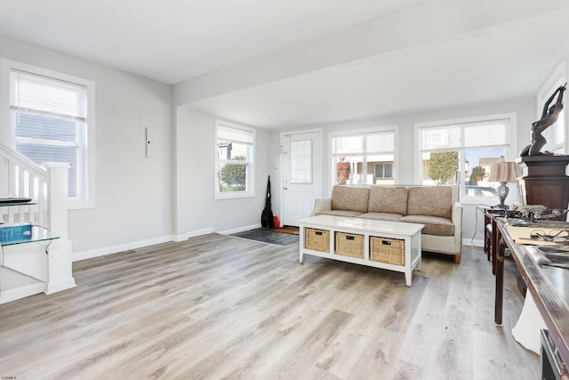 living area featuring a wealth of natural light, light wood-style flooring, and baseboards