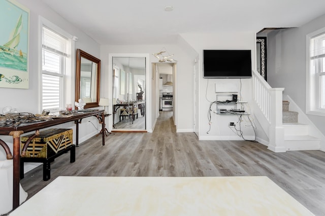 sitting room featuring a healthy amount of sunlight, light wood finished floors, and stairs