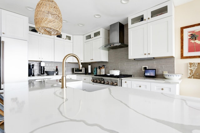 kitchen with glass insert cabinets, white cabinets, and wall chimney exhaust hood