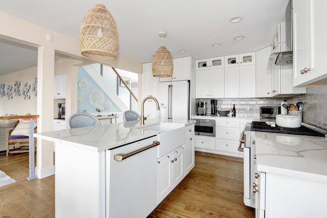 kitchen with white appliances, a center island with sink, glass insert cabinets, light stone countertops, and white cabinetry