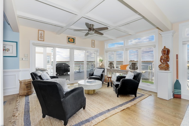 living room featuring a wainscoted wall, coffered ceiling, beam ceiling, and light wood-style floors