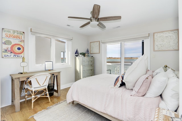 bedroom featuring a ceiling fan, visible vents, light wood-style flooring, and baseboards