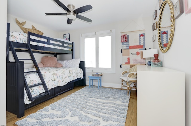 bedroom featuring ceiling fan, wood finished floors, and baseboards