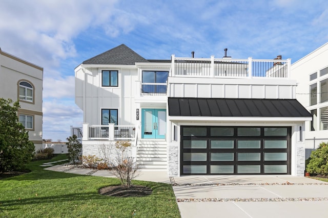 view of front of house featuring a garage, concrete driveway, a balcony, metal roof, and a standing seam roof