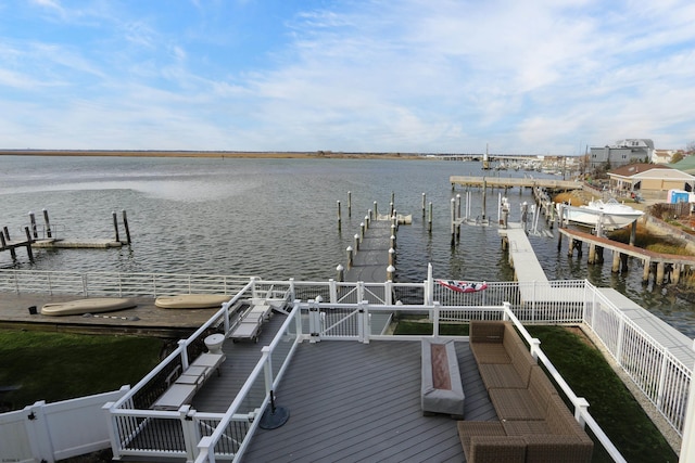 view of dock with a water view and fence