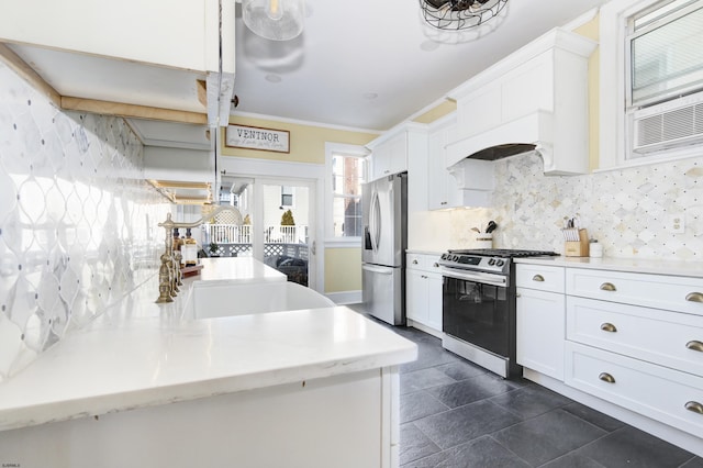 kitchen featuring stainless steel appliances, light countertops, decorative backsplash, and white cabinetry