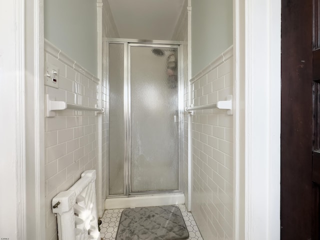 bathroom with a stall shower, tile walls, and tile patterned floors