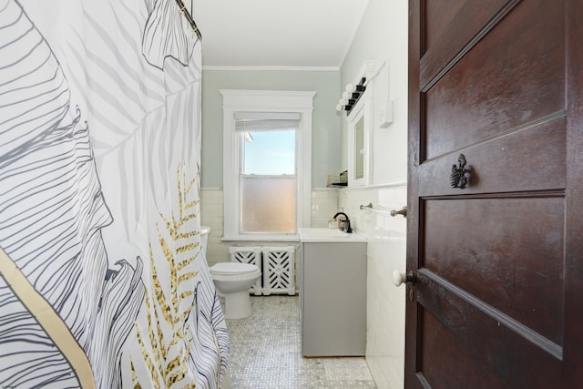 bathroom with toilet, a wainscoted wall, vanity, tile walls, and ornamental molding