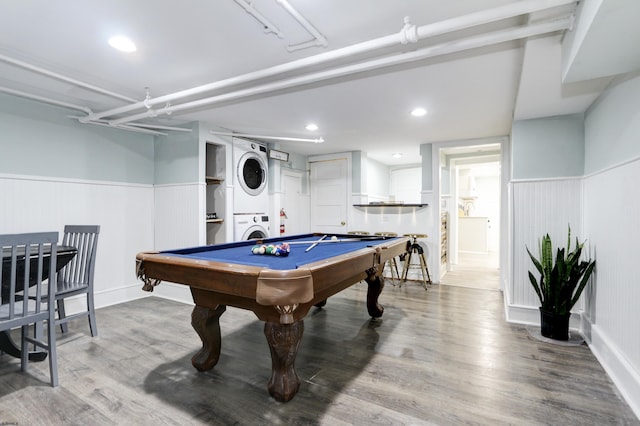 recreation room with stacked washer / dryer, a wainscoted wall, wood finished floors, pool table, and recessed lighting