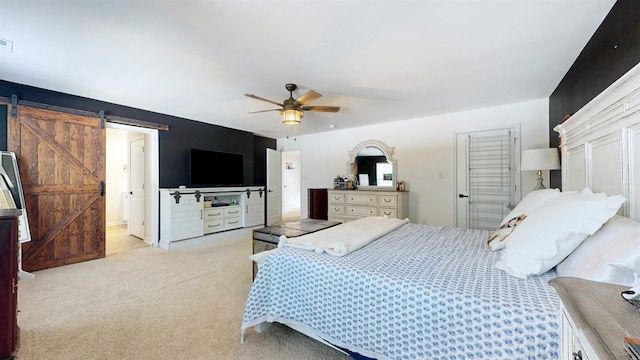 carpeted bedroom featuring ceiling fan, a barn door, and visible vents