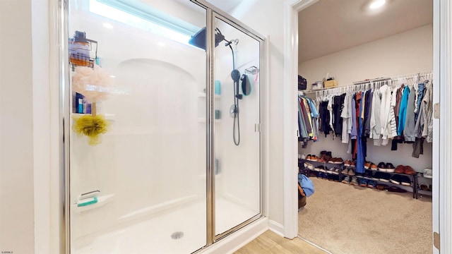 full bathroom featuring a shower stall and a spacious closet