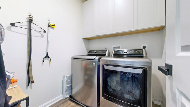 washroom with cabinet space, baseboards, light wood finished floors, and independent washer and dryer