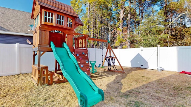 view of playground with a fenced backyard and a gate