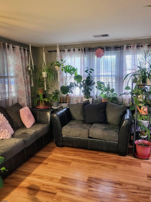 living area with light wood-style flooring and visible vents