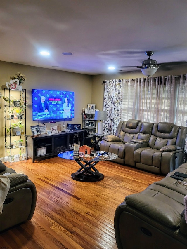 living area featuring a ceiling fan and wood finished floors