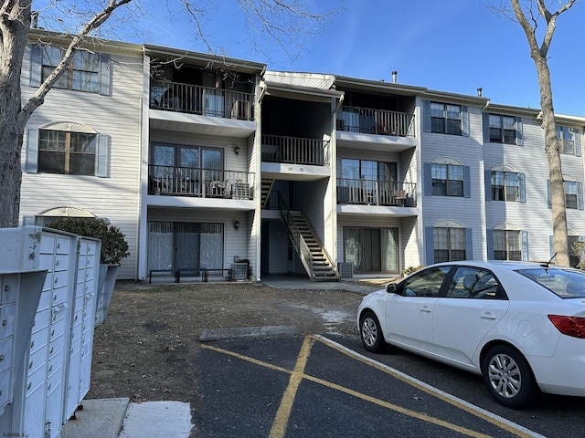 view of building exterior featuring stairs and uncovered parking