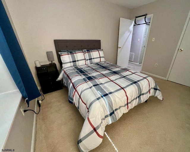 bedroom with light carpet and baseboards